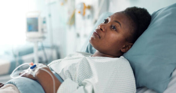 Patient resting in a hospital bed with white sheets, symbolizing comfort and recovery during a hospital stay.